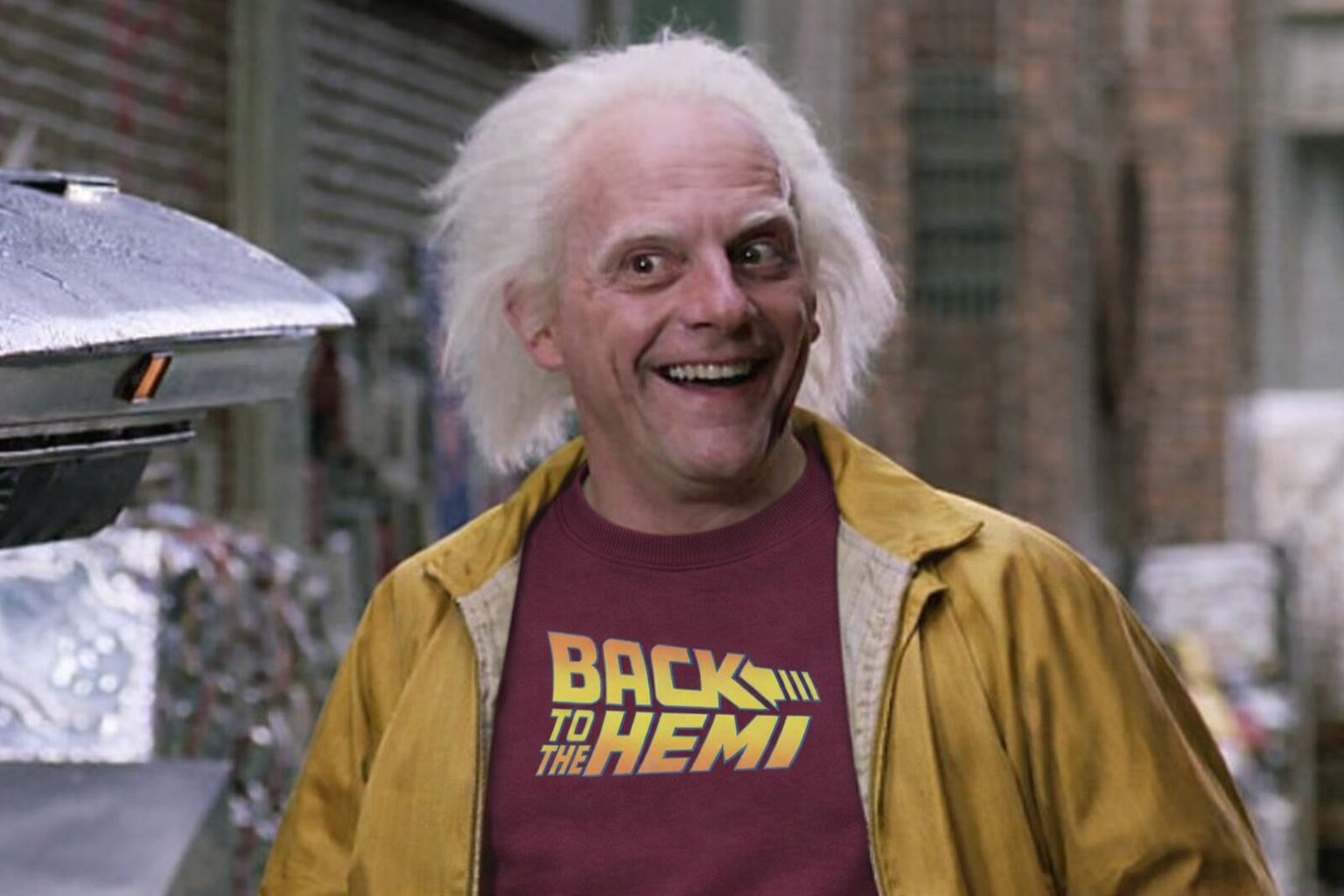 Person wearing a 'Back to the Hemi' t-shirt with a vintage car in the background